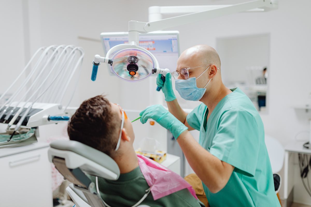 image of a dentist inspecting a patient's teeth